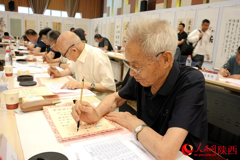 退休教師用毛筆書寫2024級新生錄取通知書。人民網記者 賈凱璐攝