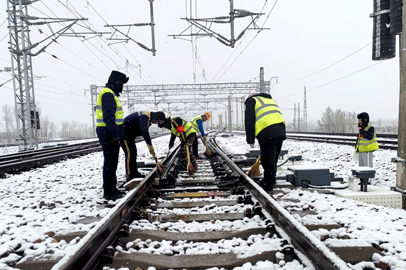 西安鐵路局綏德工電段神木西綜合維修車間職工正在進行掃雪除冰作業。劉盼利  攝